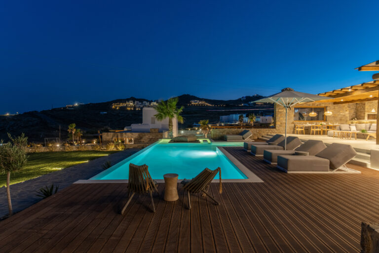 Pool and deck lit at dusk at a villa in Mykonos