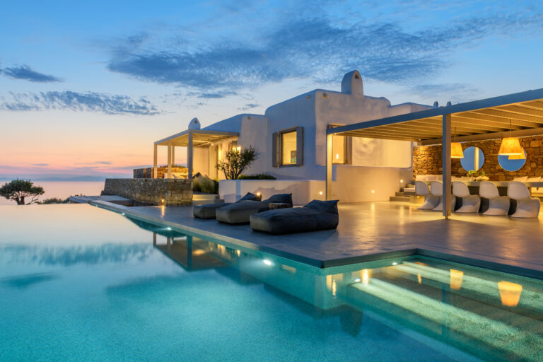 Infinity pool and terrace lounge at dusk at a villa in Mykonos