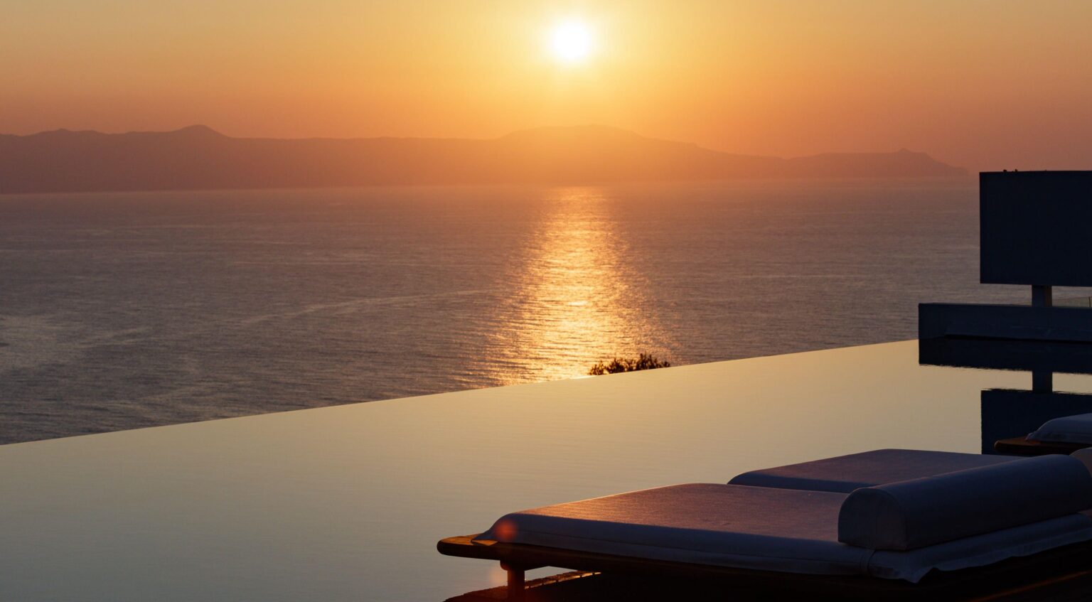 Sunset over the sea from an infinity pool terrace